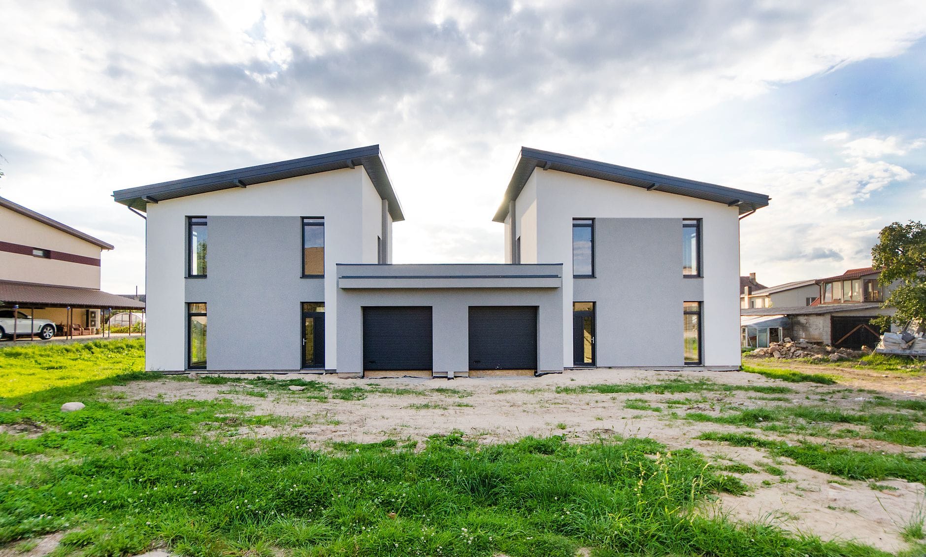 Front bliźniaczych nowoczesnych domów pod zachmurzonym niebem
