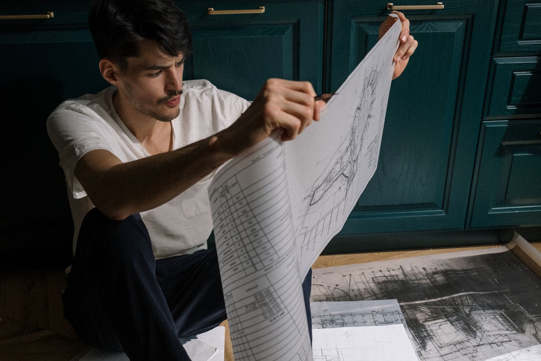 Mężczyzna przegląda plany architektoniczne w nowoczesnej kuchni