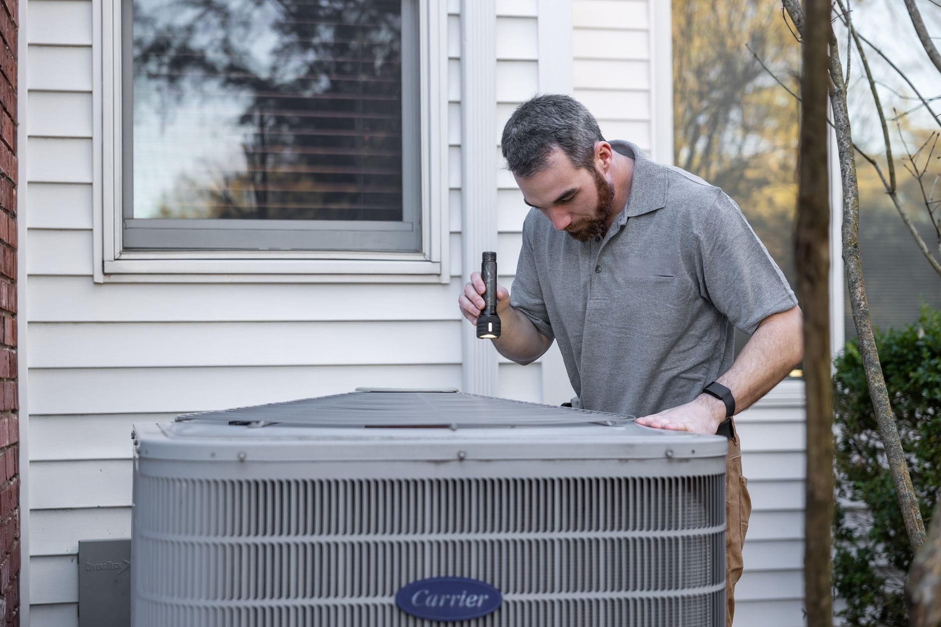 Serwisant sprawdza zewnętrzną jednostkę HVAC podczas przeglądu